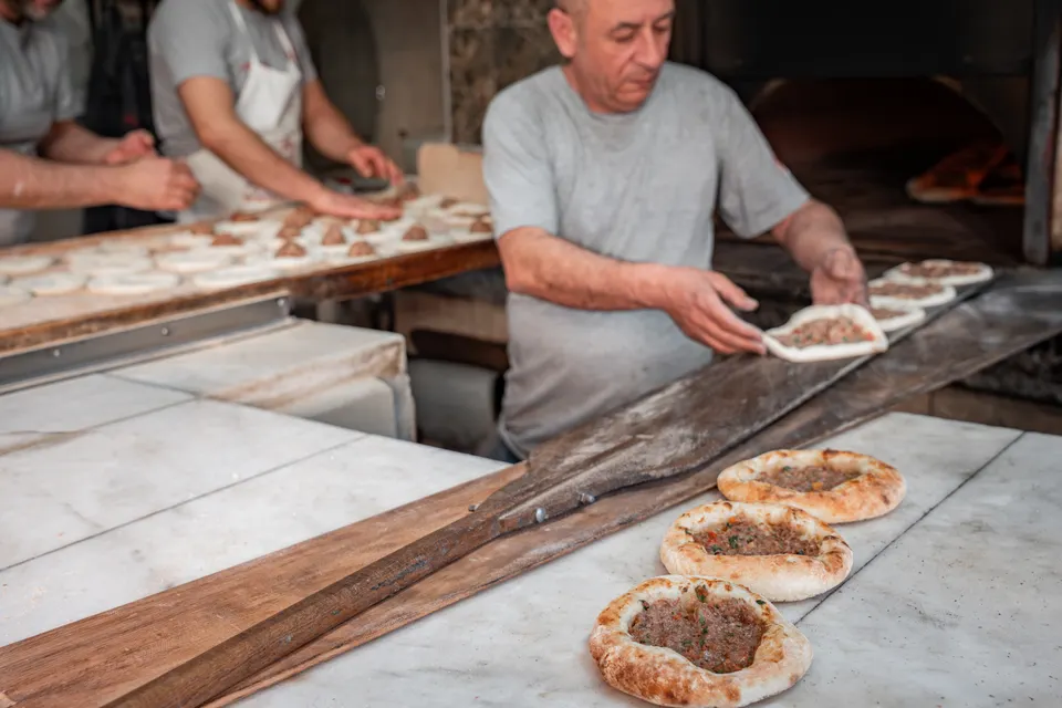 Fırıncı usta küreğiyle taş fırına hamur sürüyor